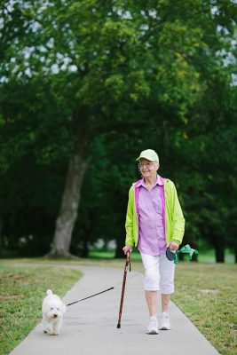 Woman taking small dog for walk outside Cordia at Grand Traverse Commons