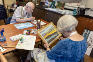 Two seniors painting pictures