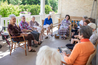 A group of ladies sitting on porch