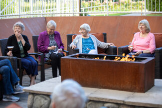 Four ladies sitting around a fire pit