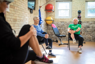 Two seniors stretching with instructor