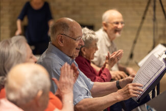 A man reading as other laugh