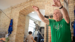 An older man doing a squat