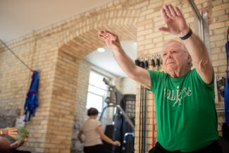 An older man doing a squat