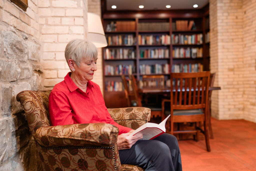 A woman sitting down and reading in a small library